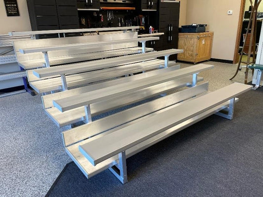 The same four-row showroom bleacher as 11.jpeg photographed from the opposite end, showing the seat plank and foot plank pairing on each row.