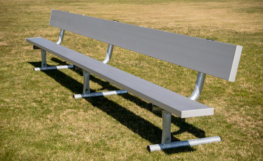 Single aluminum team bench with a full-length backrest on a galvanized steel frame with horizontal ground tubes, photographed alone on grass.