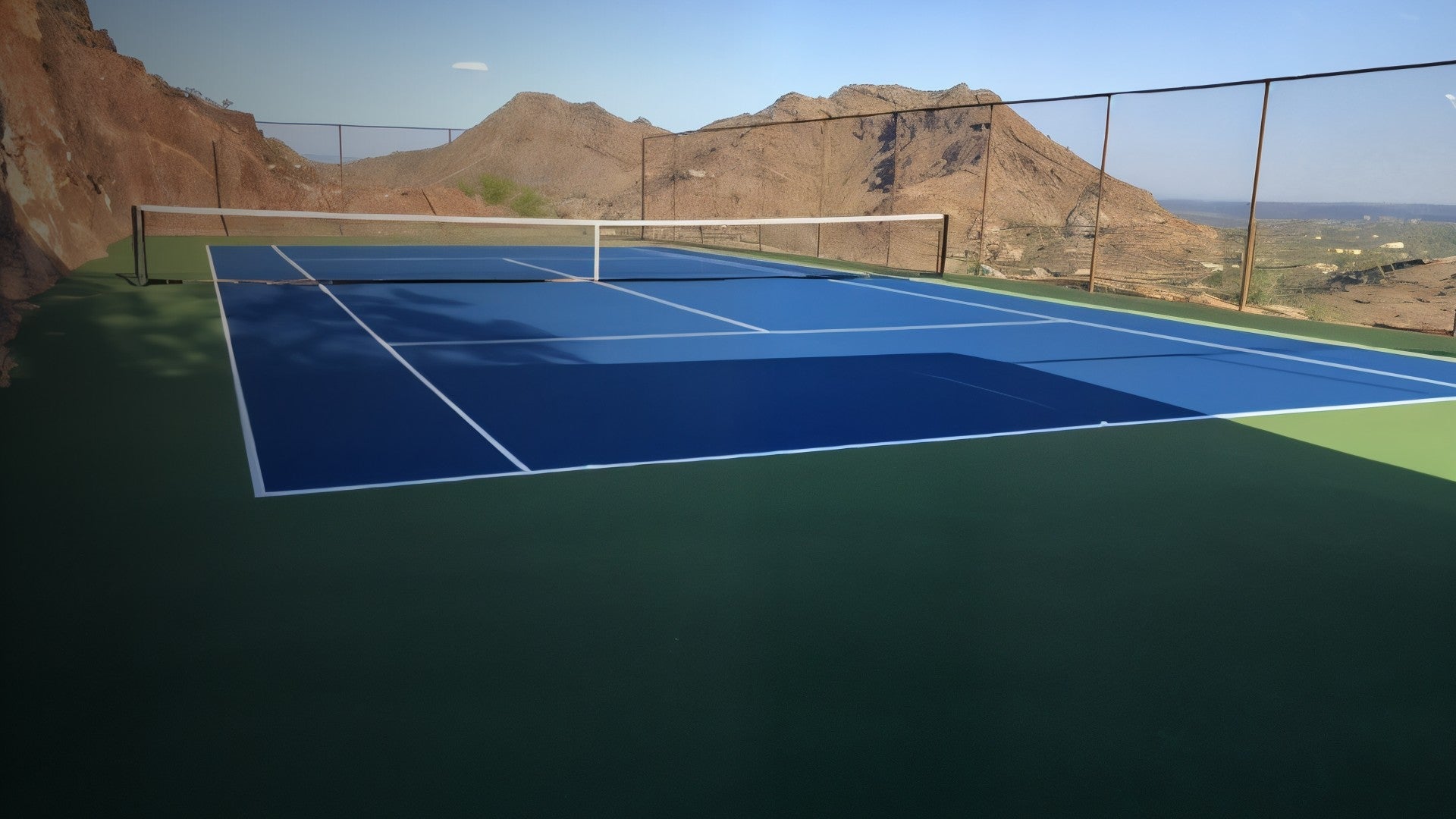 Blue and green outdoor sports court with mountain view